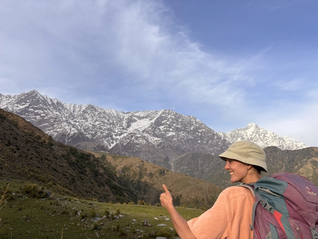 Nicole pointing at snow-capped peaks, Himalayas